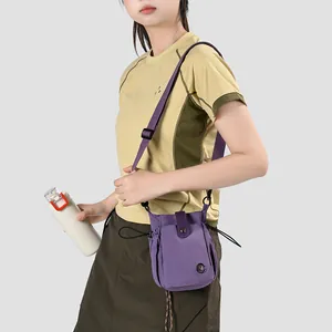 Gros plan d'un mini sac à bandoulière en nylon violet pour téléphone sur un mannequin.