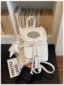Gedetailleerde weergave van een witte rugzak met kanten rand en sterretje hanger.