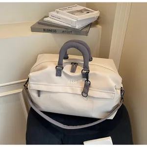 Vue détaillée du sac de voyage crème à grande capacité avec anses grises rembourrées