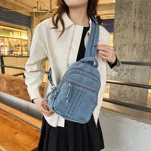 Lifestyle shot of a stylish blue denim sling bag worn by a woman in a casual setting.