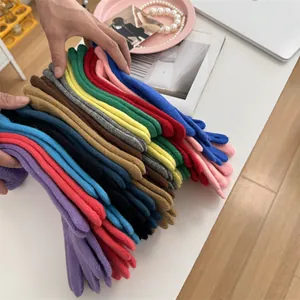 Detailed view of colorful knitted touchscreen gloves stacked in various vibrant colors