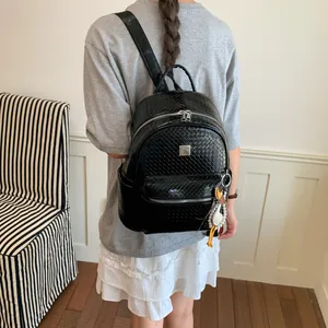 Zaino retrò nero con trama intrecciata indossato da una modella in stile preppy