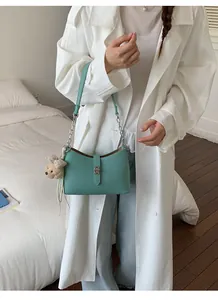 Elegante borsa sottobraccio verde menta con ciondolo a forma di orsetto e catena argento
