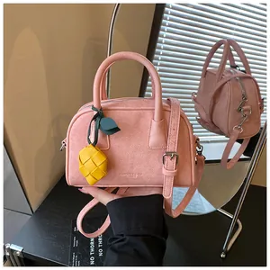 Detail view of pink leather pillow handbag with stylish lemon charm and top handle