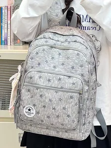 Close-up detail of a grey school backpack featuring a stylish star pattern and zippers