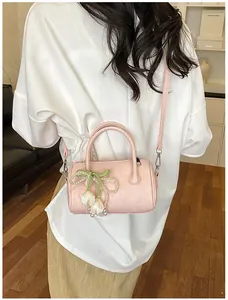 Back view of a pink pillow crossbody bag with pearl tulip charm on a white shirt