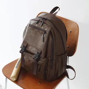 Gros plan d'un sac à dos en cuir marron rétro sur une chaise en bois à côté d'une batte