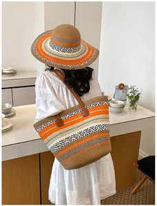 Modell mit einer gestreiften Strohtasche mit großem Fassungsvermögen und Strandhut