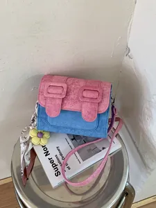 Stylish pink and blue color-block messenger bag with floral scarf and flower ornament.