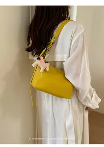Minimalist yellow leather underarm shoulder bag with cute pegasus charm for women commuting.