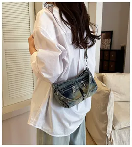 Retro distressed denim shoulder bag shown on a model in a casual lifestyle setting