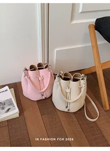 Stylish pink and beige textured leather bucket bags in an elegant indoor setting