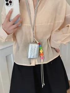 Stylish mini silver metallic crossbody pouch featuring a vibrant colorful bead charm