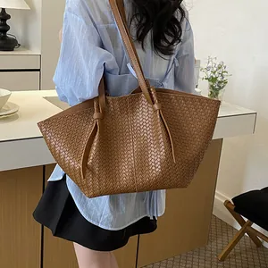 Chic brown woven shoulder bag for women styled with a minimalist outfit in a modern cafe