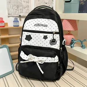 Close-up of black and white polka dot backpack with star patches and cute bow detail