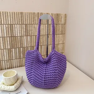 Detailed view of the purple hand-knitted underarm bag with thick rope texture