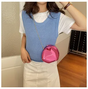 Elegante borsa da sera rosa a specchio a forma di conchiglia con catena su modella