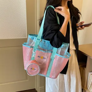 Detail view of a stylish pink and blue mesh tote bag featuring a small matching coin pouch