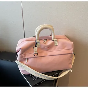 Vue de face d'un grand sac de voyage rose avec le logo ZSSJ brodé sur le devant