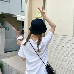 Close-up back view of a woman wearing a black Japanese style ruffled bucket hat outdoors