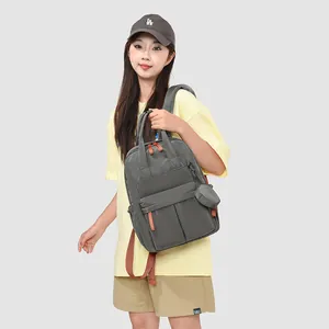 Eine asiatische Frau trägt einen leichten grauen wasserdichten Rucksack für Outdoor-Reisen