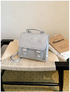 Detail of a sweet silver school-style backpack with heart and star patterns