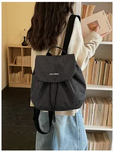 Back view of a woman wearing a checkered casual small backpack in a library setting