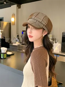 Detailansicht einer Frau mit einer britischen Retro-Karo-Schirmmütze in einem Café-Ambiente