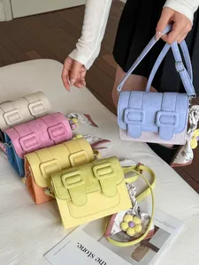 Trendy color-blocking small square crossbody bag with decorative buckles and silk scarf.