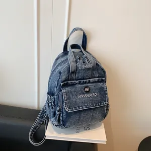 Detailansicht eines lässigen Denim-Rucksacks mit Markenlogo und Seitentaschen