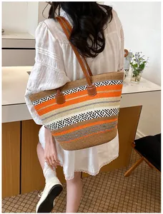 Rückansicht eines Models mit einer bunt gestreiften Strohtasche in einem modernen Café