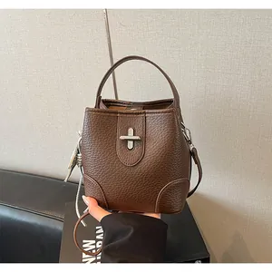 Vue détaillée d'un sac seau en similicuir marron avec fermoir pivotant argenté