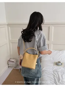 Elegant yellow woven leather bucket bag shown by a model in a cozy lifestyle setting
