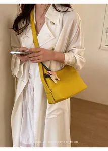 Detailed view of the yellow shoulder bag featuring a cute animal pendant for daily styling.