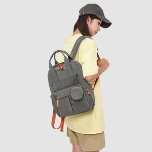 Seitenansicht eines grauen wasserdichten Reise-Rucksacks mit orangen Details am Modell