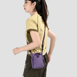 Vue détaillée d'un petit sac bandoulière violet pour téléphone porté par un mannequin