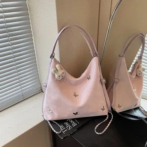 Detailed view of the pink multi-functional commuter bag featuring metal butterfly accents.