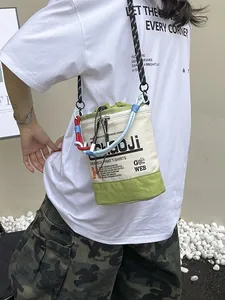 Lässige trendige Bucket-Tasche aus Segeltuch in Creme und Grün, am Modell getragen