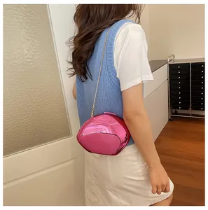 Elegante borsa da sera rosa specchiata a forma di conchiglia indossata da modella