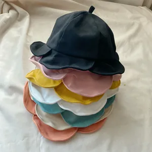Detailed view of stacked colorful bucket hats featuring elegant ruffled lotus leaf edges.