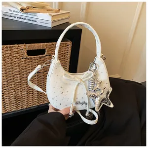 Close-up detail of a white sweet hobo bag with bow decoration and silver star patterns.