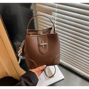 Détail du sac seau en cuir grainé marron avec fermoir tournant métallique élégant