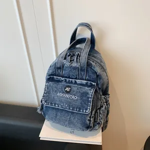 Detailansicht eines stylischen blauen Denim-Rucksacks mit Vordertasche und Logo