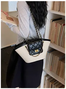 Sac cabas en paille avec rabat matelassé et bandoulières chaîne dans un décor chic.