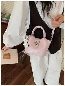 Sac seau rose tendance avec breloque chien porté par un mannequin en gros plan détaillé