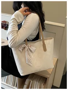 Detail view of a stylish white large capacity tote bag with embossed geometric pattern