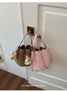 Fashionable 2026 summer bucket handbags in brown and pink featuring cute plush bear charms