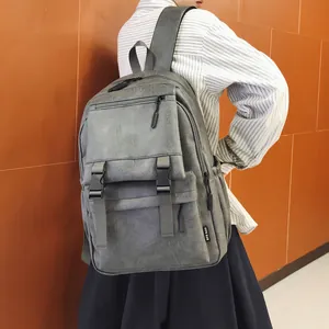 Vue détaillée d'un sac à dos vintage en cuir gris avec boucles et grande capacité de rangement