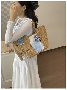 Sac cabas paille éléphant fait main porté par un mannequin pour un look de plage.