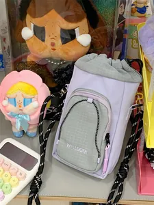 Detailansicht einer stilvollen lavendelfarbenen Umhängetasche mit Kordelzug und Gittertasche